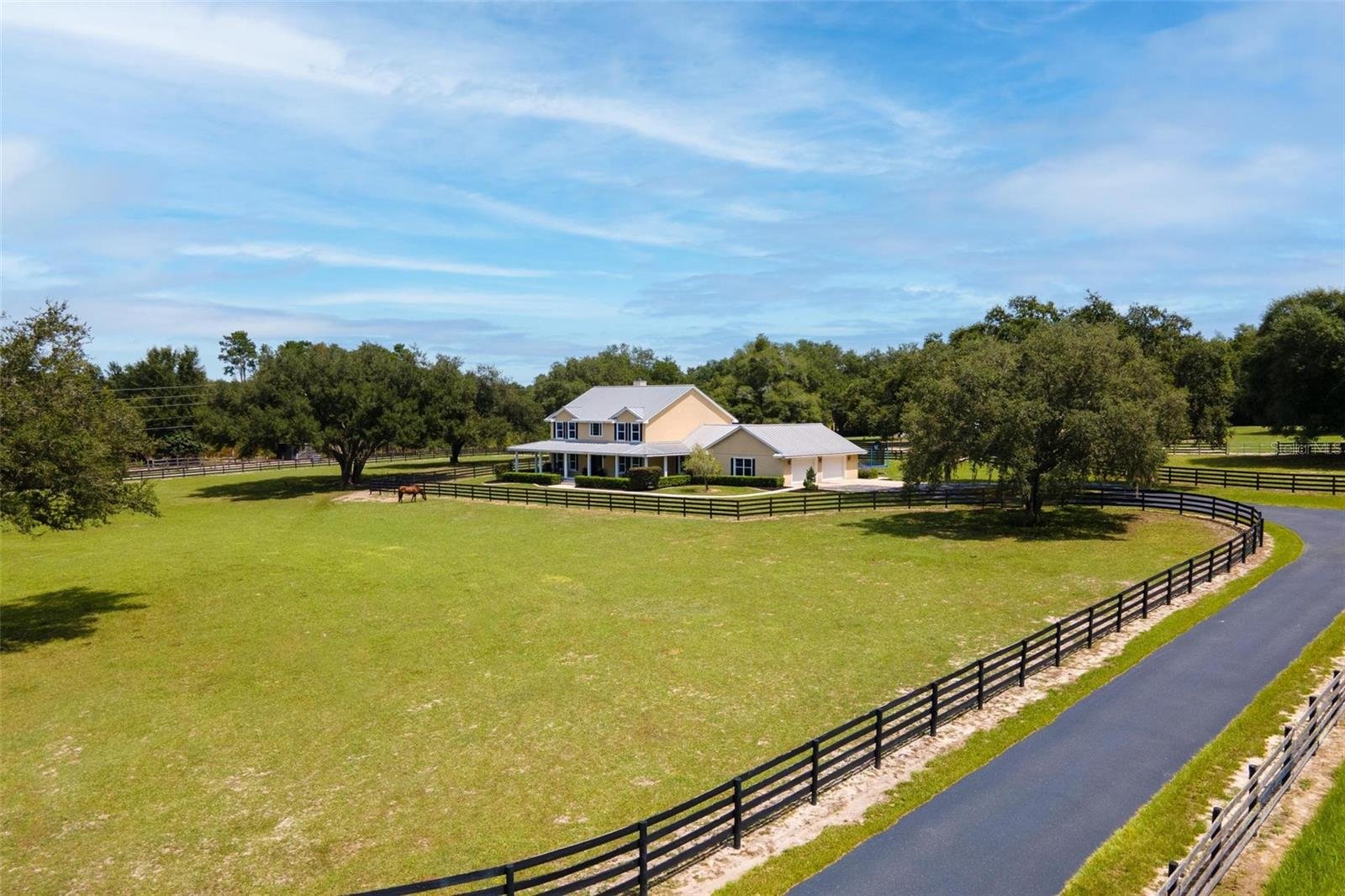 large ranch with black gate and home on the property